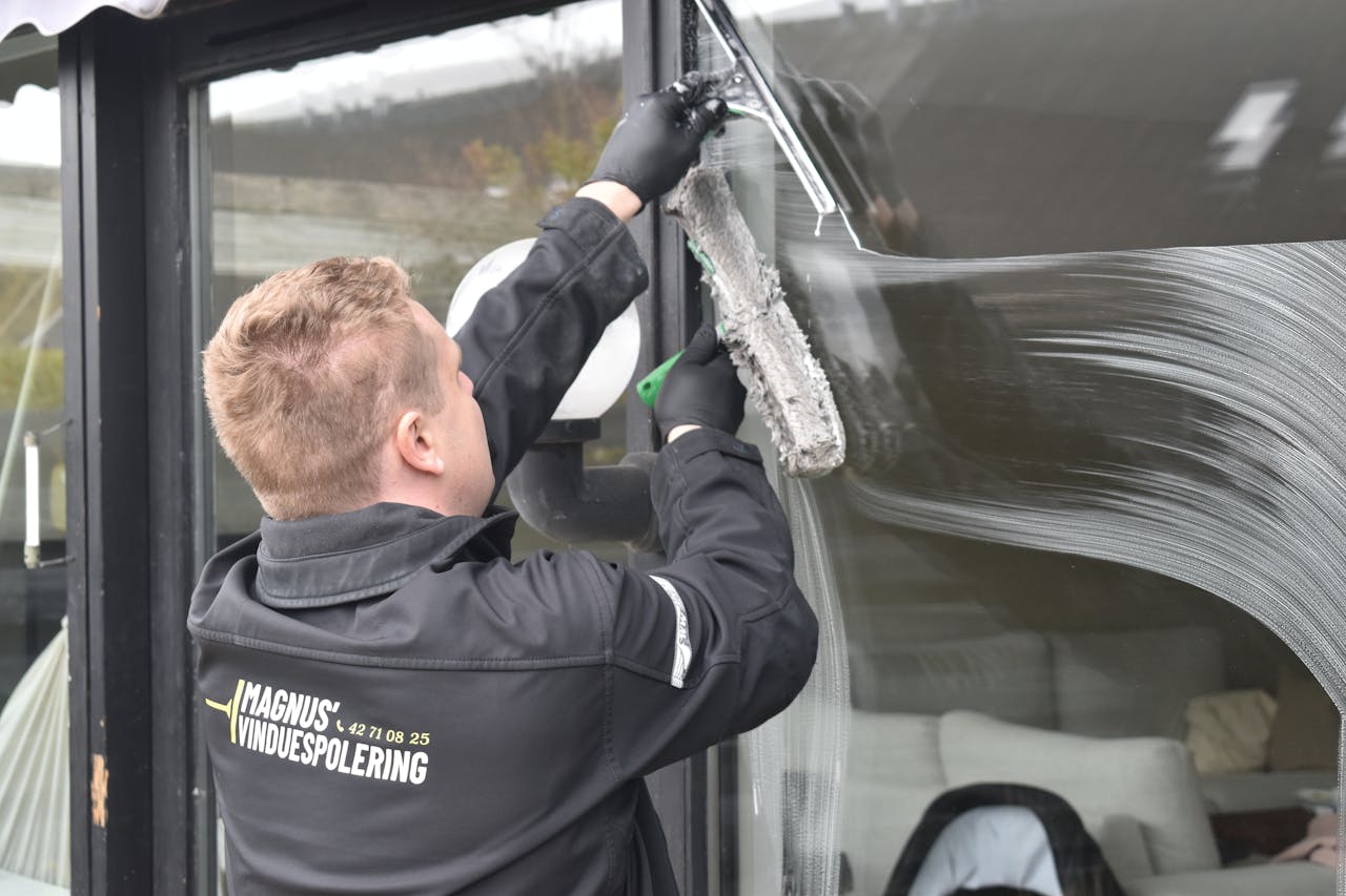 services-img Professional cleaning service washing a large glass window. Clean and efficient work by a dedicated individual.